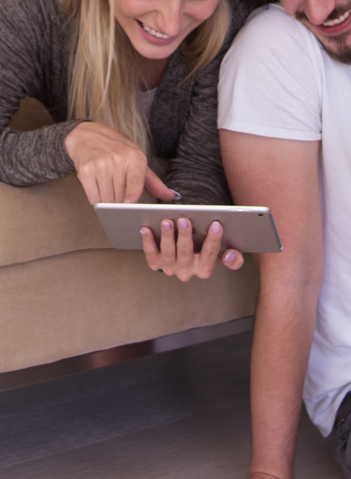 couple relaxing at  home with tablet computers